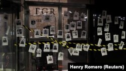 Activiști și jurnaliști închid simbolic ușile și plasează fotografii ale jurnaliștilor uciși la Procuratura Generală în timpul priveghiului în memoria lui Fredid Roman, jurnalist împușcat mortal în mașina sa, în Mexico City, 24 august 2022
