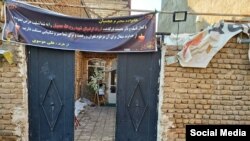 عکس از سردر خانه روح‌الله عجمیان، بسیجی‌ای که دادگستری مدعی کشته شدن او توسط ۱۱ معترض است