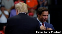 Donald Trump (cu spatele) și senatorul republican Ron DeSantis în timpul unui miting de campanie electorală în Estero, Florida, 31 octombrie 2018