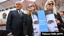 British director Sally Potter (right), U.S. actress Julianne Moore (center), and the director of the 79th Venice International Film Festival, Alberto Barbera, hold a poster showing jailed Iranian director Jafar Panahi.