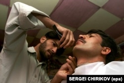 Berberin brije čoveka koji je odlučio da se otarasi brade - što je bilo zabranjeno pod talibanima, u avganistanskom gradu Talokan, novembar 2001.