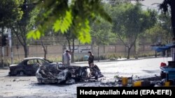 Afghan security officials inspect the scene of a bomb blast outside Kabul University in Kabul on July 19.