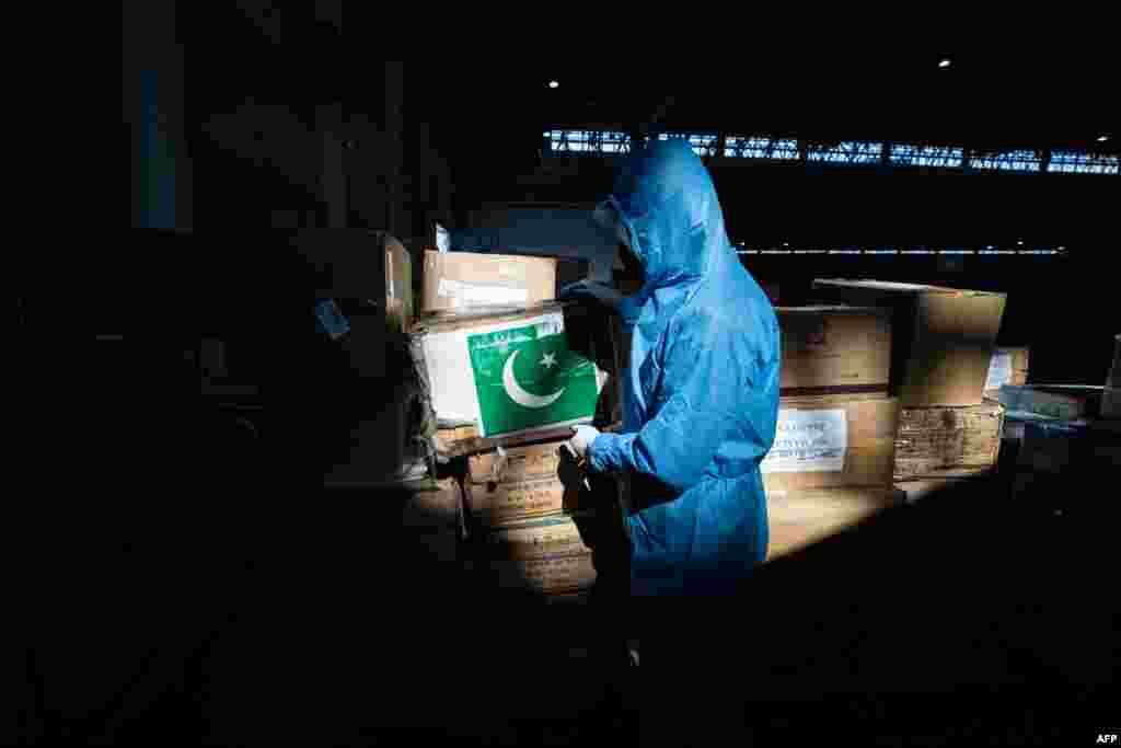 Пәкістаннан келген дәрілердің жанында тұрған медициналық қызметкер. Ухань.&nbsp;