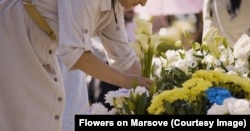 Жінка приносить квіти до могили полеглого військового на Марсовому полі