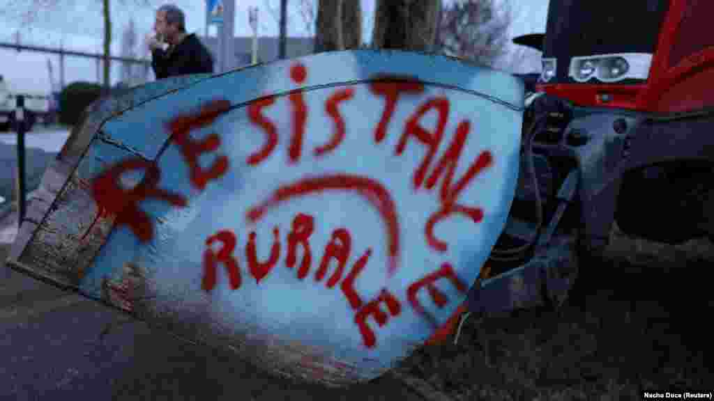 A magasabb adók és a túlzó zöldszabályozás ellen tiltakozó francia gazdák traktorral állják el&nbsp;egy&nbsp;beszerzési központ bejáratát a dél-franciaországi Castelnaudaryban 2024. január 24-én. A traktorra &bdquo;Vidéki ellenállás&rdquo; feliratot fújtak