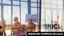 Delegatë duke kaluar pranë logos së BRICS-it, gjatë samitit të mbajtur në Johanesburg, Afrikë e Jugut, më 23 gusht 2023.