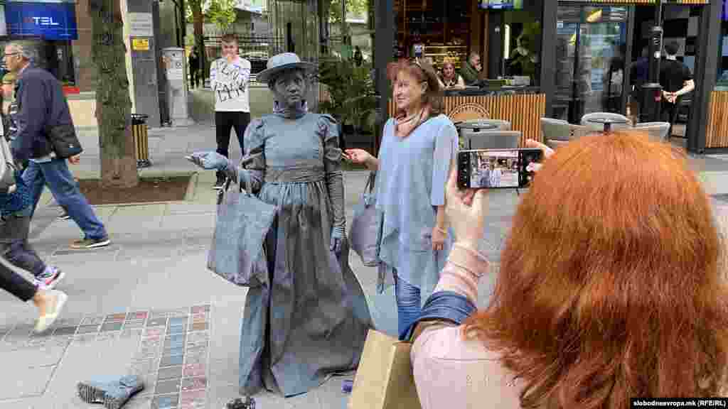 Минувачи на улица &bdquo;Македонија&ldquo; се фотографираат со живите статуи.