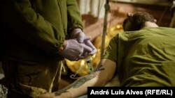 Një ushtar i plagosur ukrainas në një pikë të stabilizimit, para se të dërgohet në një spital për trajtim të mëtejmë mjekësor. 