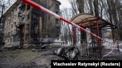 Частина російської ракети лежить на землі біля житлового будинку, пошкодженого внаслідок російського ракетного удару, 23 січня 2024 року