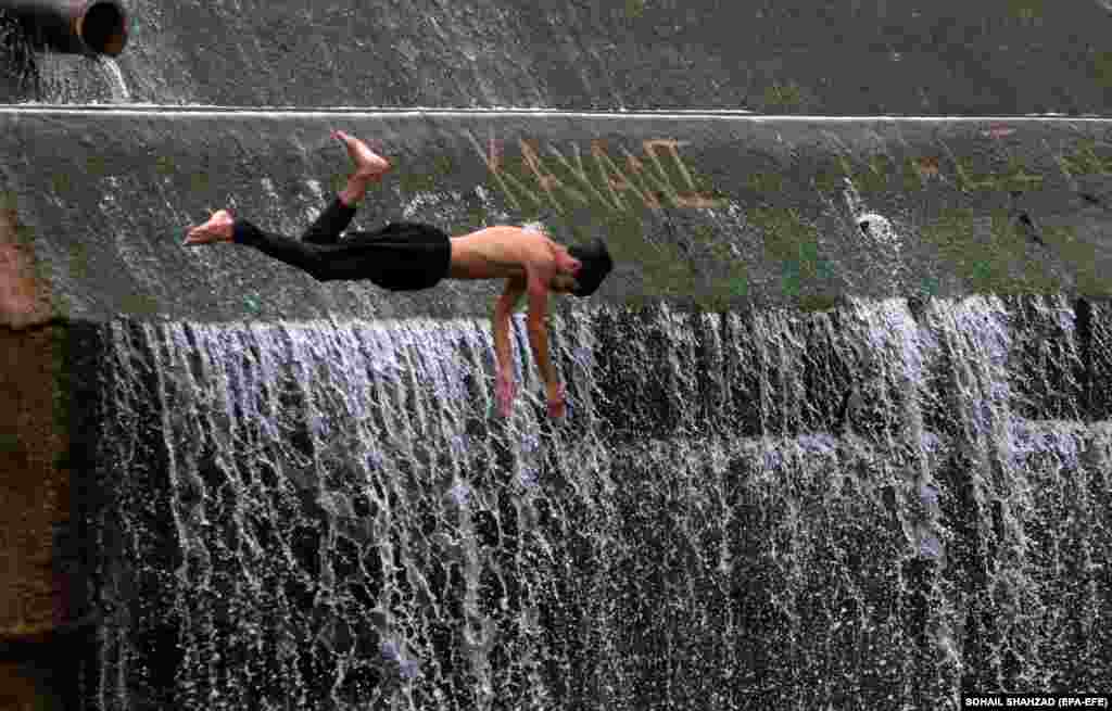 Pakistanski dječak skače u vodu sa brane Angori kako bi pobijedio vrućinu u Islamabadu.