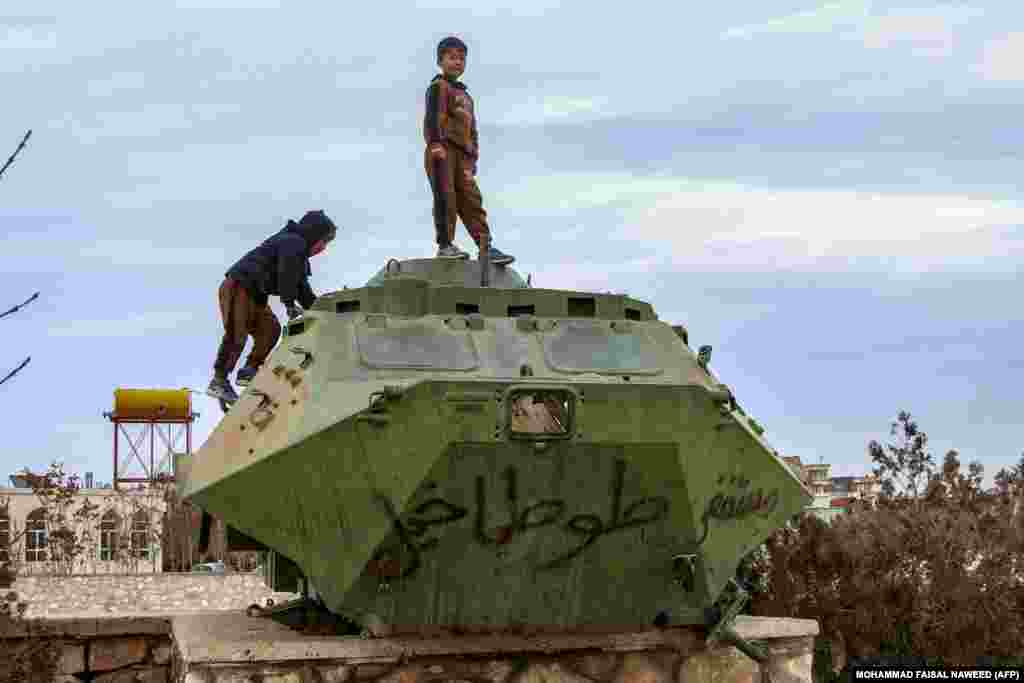 Ооганстандык балдар Газнидеги музейдин алдында советтик доордон калган танктын үстүндө ойноп жатышат.