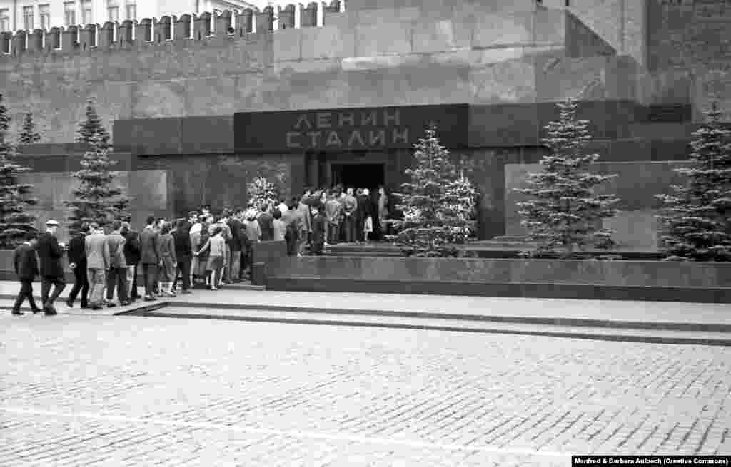 Vizitatorii intră în ceea ce a devenit mausoleul lui Lenin și Stalin, în august 1957. După moartea lui Iosif Stalin, în 1953, cadavrul său a fost îmbălsămat și expus alături de cel al lui Lenin. Mausoleul a fost adaptat pentru a afișa numele celor doi dictatori sovietici deasupra intrării.