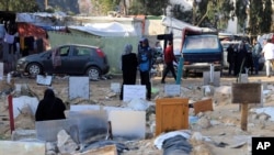 Palestinienii vizitează mormintele persoanelor ucise în bombardamentul israelian asupra Fâșiei Gaza și îngropate în incinta Spitalului Shifa din orașul Gaza, duminică, 31 decembrie 2023. (AP Photo/Mohammed Hajjar)