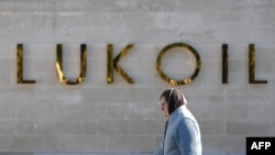 Илустрација, Жена поминува покрај седиштето на рускиот производител на нафта Лукоил во Москва