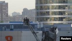 Zyrtarët rusë duke kryer hetime në vendin ku ka rënë droni në Moskë. 18 gusht 2023.