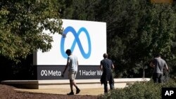 Zaposleni u Fejsbuku fotografišu se ispred novog natpisa Meta Platforms Inc. ispred sedišta kompanije u Menlo Parku, Kalifornija, 28. oktobar 2021.