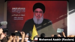 Utcai kivetítőn követik az emberek a Hezbollah-vezér beszédét Bejrútban 2023. november 3-án