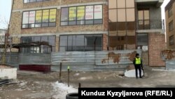 Талаш жараткан имаратты милиция кызматкерлери курчоого алып, киши киргизбей турат. 2-март 2024-жыл.