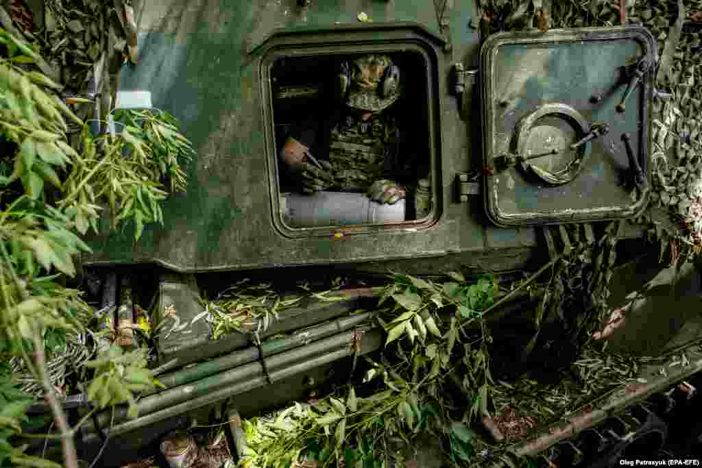 Un luptător ucrainean se pregătește să semneze un proiectil pentru un obuzier autopropulsat Akatsiâa în regiunea Donețk în iulie 2023. Irina Ribakova spune că mesajele pot servi și ca o metodă de ridicare a moralului trupelor și de descărcare psihologică. &bdquo;Uneori este doar un blestem pentru inamic.&rdquo; Adesea, spune ea, &bdquo;oamenii scriu numele camarazilor lor morți pe care speră să-i răzbune cu acest obuz.&rdquo; &nbsp; 