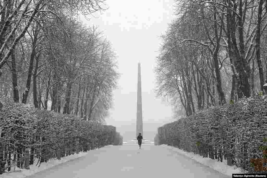 Një grua duke ecur në një park të mbuluar nga bora, në Kiev, Ukrainë, më 22 nëntor.