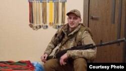 Володимир Коляда біля нагород племінника Андрійка. Березень 2022. Село Софіївська Борщагівка.