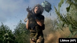 Un soldat ucrainean trage cu un lansator de grenade propulsate de rachete spre pozițiile rusești de pe linia frontului din apropiere de Donețk, la 19 august.