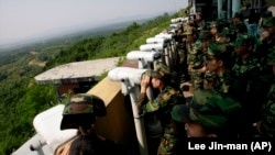 Južnokorejski vojnici gledaju preko demarkacione linije gde je američki vojnik prešao u Severnu Koreju.