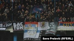 Navijači Srbije sa NATO zastavom koju su zapalili.