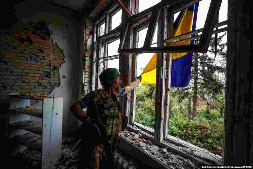 Український військовий із позивним &laquo;Борода&raquo; з 68-ї окремої єгерської бригади імені Олекси Довбуша розправляє український прапор у звільненому селі Благодатне на Донеччині. Червень 2023 року&nbsp;