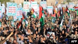 Хуситы скандируют лозунги и размахивают палестинскими флагами во время марша солидарности с жителями сектора Газа. Сана, 24 ноября 2023 года