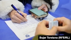 Një qytetare në Mitrovicë të Veriut duke nënshkruar peticionin për nisjen e procesit të largimit të kryetarëve shqiptarë në komunat në veri të Kosovës. 17 janar 2024. 