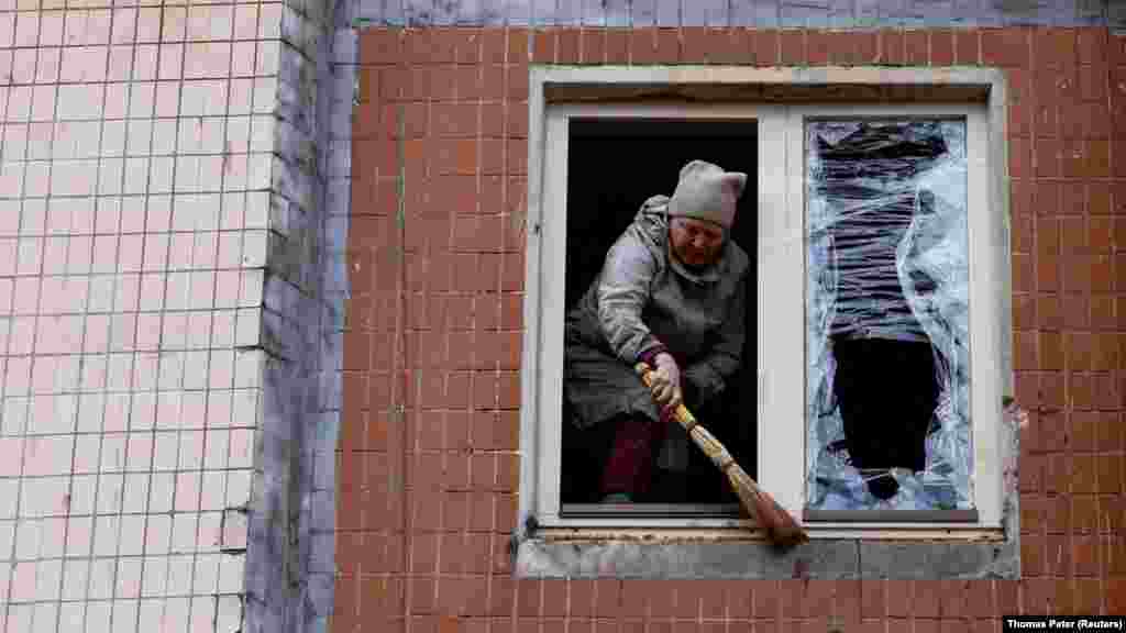 Жена чисти урнатини од станбена зграда по нападот.