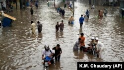Ljudi se probijaju kroz poplavljeni put u Lahoreu, Pakistan, 26. jula.