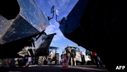 Demonstranti pored traktora nasuprot žandarmerijskim oklopnim vozilima Berliet na autoputu u blizini pariškog aerodroma Šarl de Gol, 31. januar 2024. godine