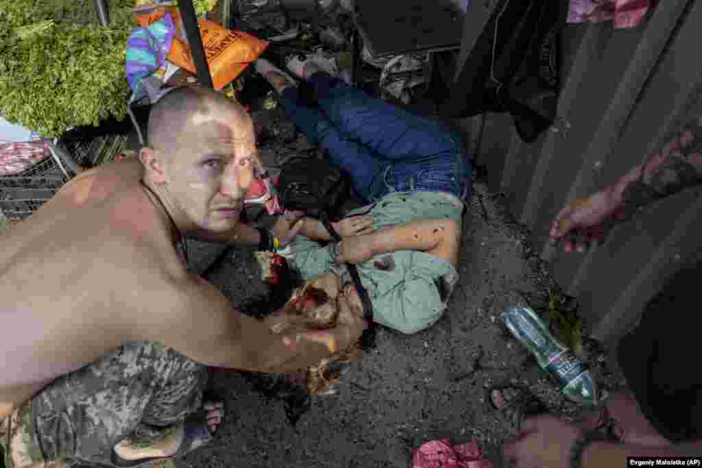 A man checks for the pulse of a woman who died in the attack.&nbsp;