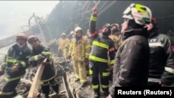 Pompieri la nivelul inferior al acoperișul prăbușit al Crocus City. Atacatorii au ucis în două feluri: trăgând în spectatorii deja adunați în sala de concert din clădirea mall-ului și dând foc cu o substanță puternic inflamabilă.