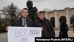 Кримські активісти з Бахчисарая Андрій Щекун (п) і Денис Недоступ тримають плакат «Ні війні! Ми за мир!». Сімферополь, 02 березня 2014 року