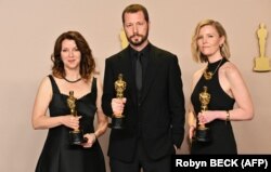 Український режисер Мстислав Чернов (посередині), Рені Аронсон-Рат і Мішель Мізнер (праворуч) позують з премією «Оскар» за найкращий документальний фільм – кінострічку «20 днів у Маріуполі». Голлівуд, 10 березня 2024 року