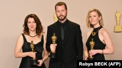 Український режисер Мстислав Чернов (посередині), Рені Аронсон-Рат і Мішель Мізнер (праворуч) позують з премією «Оскар» за найкращий документальний фільм –кінострічку «20 днів у Маріуполі». Голлівуд, 10 березня 2024 року