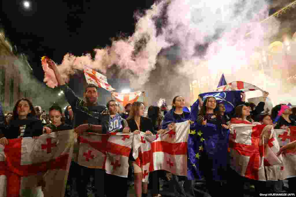  Tblisi, Georgia, 21 aprilie. Protestatari cu steaguri georgiene și europene, în fața Parlmentului de la Tbilisi. Oamenii manifestează împotrova legii &bdquo;influenței străine&rdquo;. Mii de georgieni au ieșit în stradă pentru a protesta împotriva proiectului de lege, după ce partidul de guvernământ i-a dat initial undă verde, în ciuda disputelor din parlament. Legea a stârnit, de asemenea, proteste în masă când a fost introdusă pentru prima dată anul trecut, determinând guvernul să retragă proiectul de lege. &nbsp; 