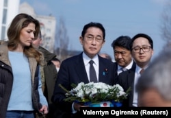 Жапон өкмөт башчысы Фумио Кисида Орусиянын Украинага каршы согушунда жабыр тарткан Буча шаарындагы жалпы көрүстөнгө гүлдесте койду. 21.3.2023.