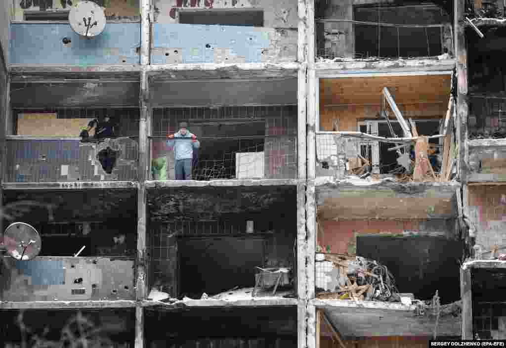 Radnici i volonteri rade u oštećenoj zgradi u Kijevu dva dana posle ruskog raketnog udara na ukrajinsku prestonicu.