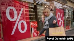 Ilustrativna fotografja: Žena u Berlinu hoda pored prodavnica sa sniženjima, 1. april 2022.
