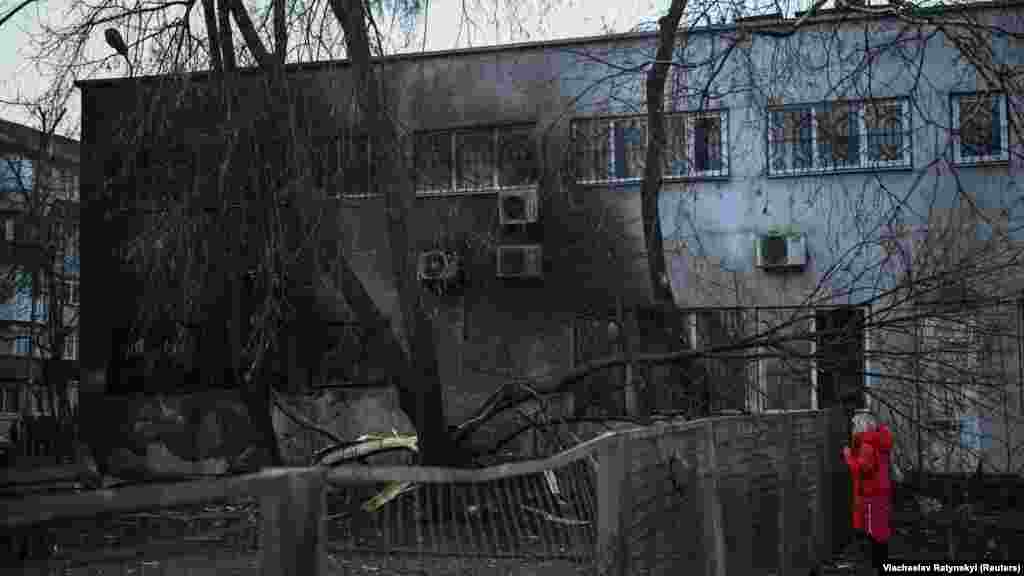 Жител ја гледа штетата на станбена зграда по нападот.