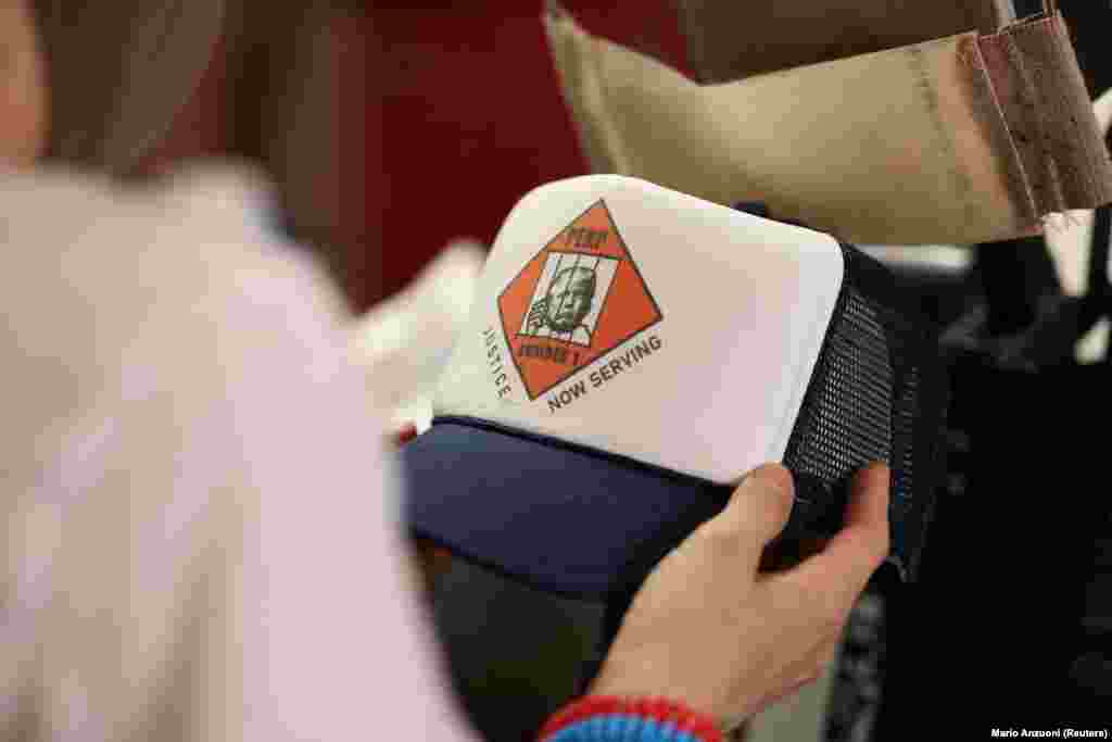 A volt elnök arcképét ábrázoló baseballsapka egy Los Angeles-i boltban augusztus 25-én. A rabosítási fényképből nemcsak Trump stábja, hanem mások is igyekeznek hasznot húzni. Az elmúlt napokban számtalan mém és árucikk jelent meg az interneten, amely ugyanezzel a képpel szintén Trump oldalán vagy ellene kampányol