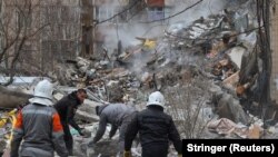 Кыйраган көп кабаттуу үйдүн урандылардын алдында калган адамдарды издөө иши уланууда, Одесса, 2-март 2024-жыл.