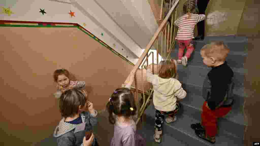 Gyerekek térnek vissza az óvoda pincéjében lévő légvédelmi óvóhelyről a riadó végeztével. Legtöbbjük szinte már nem is emlékszik, milyen a normális hétköznapokban élni.