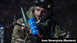Український військовослужбовець батальйону ударних безпілотників 92-ї бригади «Ахілл» прикріплює снаряд до FPV-дрона поблизу міста Бахмут Донецької області, Україна, 2 лютого, 2024 року
