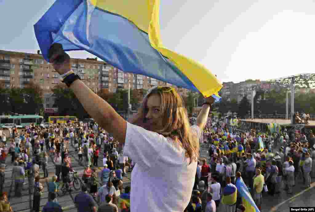 O fată flutură un steag în timpul unui miting pro-ucrainean în Mariupol, în august 2014. În vara anului 2014, Mariupol era din nou ferm în mâinile ucrainenilor și avea să rămână așa până când Rusia a lansat invazia sa la scară largă din 2022. Mariupol a fost înconjurat de forțele rusești la începutul anului 2022. Ele au declanșat un asediu care a distrus o mare parte din oraș și a ucis mii de soldați și civili.