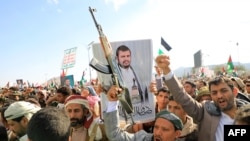 Demonstranti, jedan sa portretom vođe Hutija Abdula Malika al-Houtija, uzvikuju slogane tokom marša solidarnosti sa stanovnicima Gaze u glavnom gradu Sani koji kontrolišu Huti, 5. januara 2024.